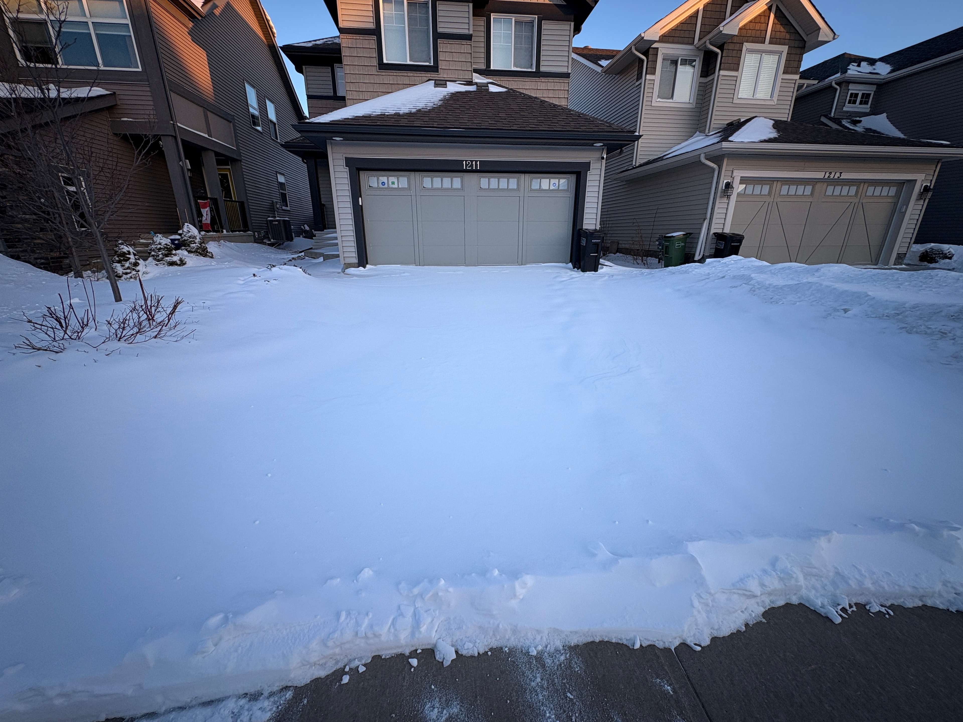 Snow-covered residential driveway before snow removal service